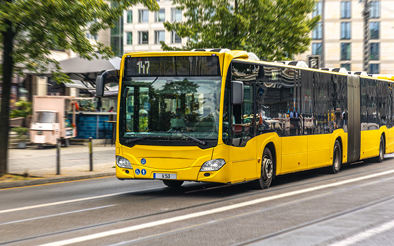 A large yellow shuttle bus traveling on a Singapore road